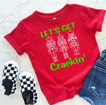 Load image into Gallery viewer, Red t-shirt with 'Let's Get Crackin'' text and nutcracker graphics, checkered shoes, and jeans on a white background