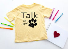 Load image into Gallery viewer, Yellow t-shirt with 'Talk to the paw' text on a white surface with pens and a heart.