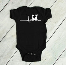Load image into Gallery viewer, Black baby bodysuit with a cat heart rate design on a light wooden floor