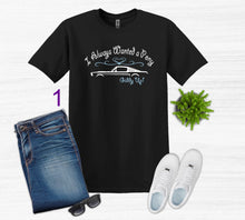 Load image into Gallery viewer, Black t-shirt with graphic design, blue jeans, white sneakers, sunglasses, and a plant on a white background