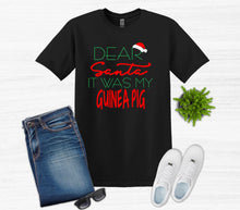 Load image into Gallery viewer, Black t-shirt with Christmas-themed text, jeans, white sneakers, sunglasses, and a plant on a light gray background