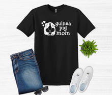 Load image into Gallery viewer, Black t-shirt with 'guinea pig mom' text and graphic, paired with jeans, sneakers, and sunglasses on a white background.