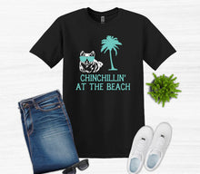 Load image into Gallery viewer, Black t-shirt with 'Chinchillin' at the Beach' design, jeans, white sneakers, sunglasses on a white background