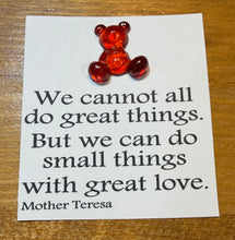 Load image into Gallery viewer, Red glass bear on a card with a quote by Mother Teresa on a wooden surface