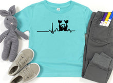 Load image into Gallery viewer, Light blue t-shirt with cat design, gray shoes, gray pants, and a gray rabbit toy on a white background