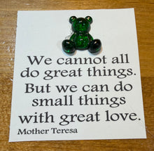 Load image into Gallery viewer, Green teddy bear on a card with a quote by Mother Teresa on a wooden surface