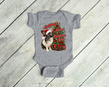 Load image into Gallery viewer, A heather gray short-sleeve baby bodysuit laid flat on a light wood plank background. The front features a festive graphic of a rabbit wearing a Santa hat next to a decorated Christmas tree and the text 'Hoping Around the Christmas Tree'.