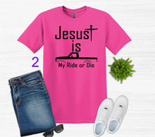 Load image into Gallery viewer, Pink t-shirt with 'Jesus is my ride or die' text, paired with jeans, sneakers, and sunglasses on a white background.