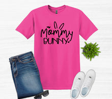 Load image into Gallery viewer, Pink t-shirt with 'Mommy Bunny' text, blue jeans, white sneakers, and sunglasses on a light gray background.