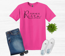 Load image into Gallery viewer, Pink t-shirt with 'For He is Risen' text, blue jeans, white sneakers, sunglasses, and a plant on a white background
