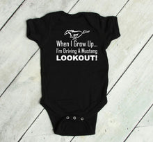 Load image into Gallery viewer, Black baby bodysuit with white text and logo on a light wooden floor.