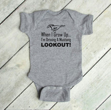 Load image into Gallery viewer, Gray baby bodysuit with text and Mustang logo on a wooden floor