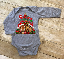 Load image into Gallery viewer, A heather gray long-sleeve baby bodysuit with a festive Christmas guinea pig graphic, laid flat on a rustic wooden plank background. The graphic features two guinea pigs wearing Santa hats under the text 'Wheeking around the Christmas tree'.