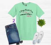 Load image into Gallery viewer, Green t-shirt with text, jeans, sneakers, sunglasses, and a plant on a white background