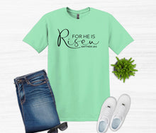 Load image into Gallery viewer, Mint green t-shirt with 'For He is Risen' text, jeans, white sneakers, and sunglasses on a white background.
