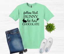 Load image into Gallery viewer, Green t-shirt with text, blue jeans, white sneakers, sunglasses, and a small plant on a white background