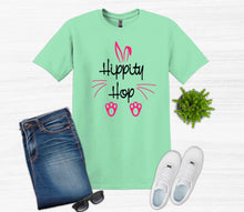 Load image into Gallery viewer, Mint green t-shirt with 'Hippity Hop' text and bunny ears design, paired with jeans, sneakers, and sunglasses on a white background.