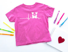Load image into Gallery viewer, Pink t-shirt with a cat white graphic design on a white background with colorful pens and a heart.