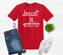 Load image into Gallery viewer, Red t-shirt with 'Jesus is my ride or die' text, paired with jeans, sneakers, and sunglasses on a white background.