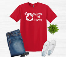 Load image into Gallery viewer, Red t-shirt with 'guinea pig mom' text, blue jeans, white sneakers, and sunglasses on a light gray background.