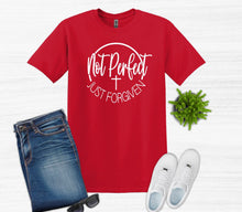 Load image into Gallery viewer, Red t-shirt with 'Not Perfect Just Forgiven' text, blue jeans, white sneakers, sunglasses on a white background.