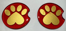 Load image into Gallery viewer, Two red and gold paw print coasters on a white background