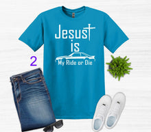 Load image into Gallery viewer, Blue t-shirt with 'Jesus is my ride or die' text, paired with jeans and sneakers on a white background.