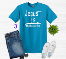 Load image into Gallery viewer, Blue t-shirt with 'Jesus is My Ride or Die' text, paired with jeans, sneakers, and sunglasses on a white background.