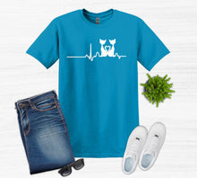 Load image into Gallery viewer, Blue t-shirt with a cat design, jeans, white sneakers, sunglasses, and a plant on a white background