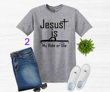 Load image into Gallery viewer, Gray t-shirt with 'Jesus is my ride or die' text, paired with jeans, shoes, and sunglasses on a white background.