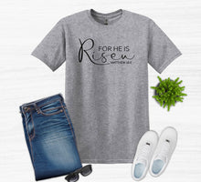 Load image into Gallery viewer, Gray t-shirt with 'For He is Risen' text, blue jeans, white sneakers, sunglasses, and a plant on a light gray background