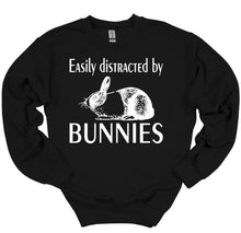 Load image into Gallery viewer, Black sweatshirt with white text 'Easily distracted by Bunnies' and a bunny illustration on a white background.