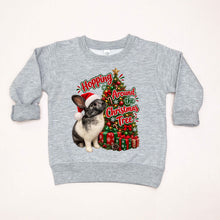 Load image into Gallery viewer, A light heather gray long-sleeve crewneck sweatshirt featuring a festive Christmas graphic of a black and white rabbit wearing a Santa hat next to a decorated Christmas tree and wrapped gifts, with the text 'Hopping Around the Christmas Tree'.