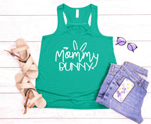 Load image into Gallery viewer, Green tank top with 'Mommy Bunny' text, sandals, sunglasses, and denim shorts on a wooden surface.