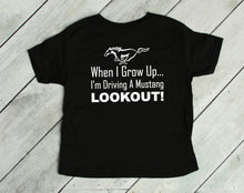 Load image into Gallery viewer, Black t-shirt with white text and horse graphic on a wooden floor.