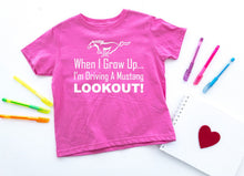 Load image into Gallery viewer, Pink t-shirt with Mustang graphic and text on a white background with markers and a heart.