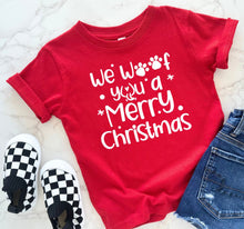 Load image into Gallery viewer, Red t-shirt with 'we woof you a Merry Christmas' text, checkered shoes, and jeans on a light background