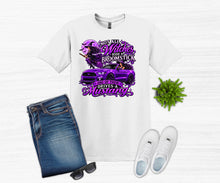 Load image into Gallery viewer, A white graphic t-shirt displayed in a flat-lay arrangement with folded blue jeans, white sneakers, sunglasses, and a small green plant on a light wood background. The t-shirt features a purple graphic of a woman driving a purple Mustang with the text 'NOT ALL Witches Ride A Broomstick One of them Drives A Mustang'.