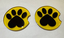 Load image into Gallery viewer, Two yellow coasters with black paw prints on a white background
