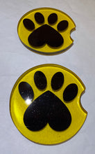 Load image into Gallery viewer, Two yellow car coasters with black paw prints on a white background