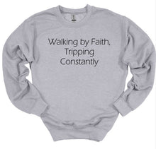 Load image into Gallery viewer, Gray sweatshirt with text 'Walking by Faith, Tripping Constantly' on a white background